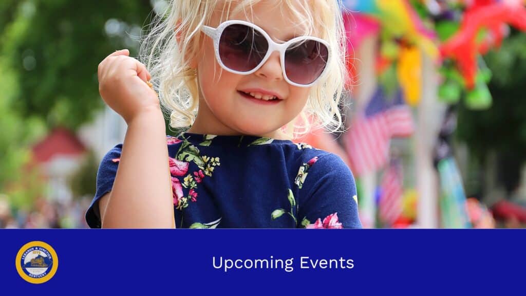 Young child wearing sunglasses with festival decor in the background